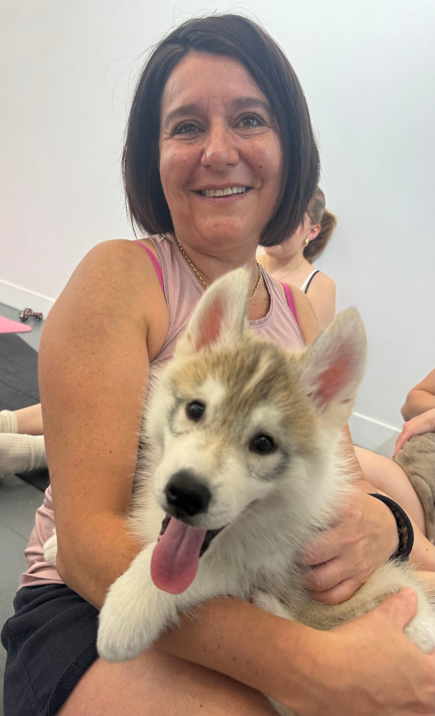 Una participante de Puppy Yoga con un Husky